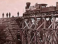 Photograph of locomotive on a railroad bridge, from 1865.