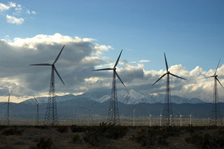 Windmills in a wind farm, mountains in the background.