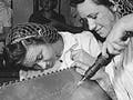 Photo of female trainees working on a practice bomb shell, 1942.