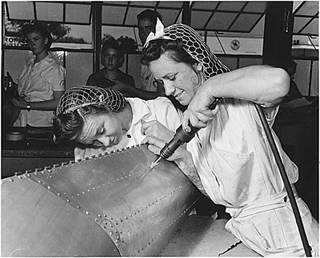 Photo of female trainees working on a practice bomb shell, 1942.