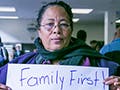 A woman holds up a sign that reads "Family First! Reform now!"